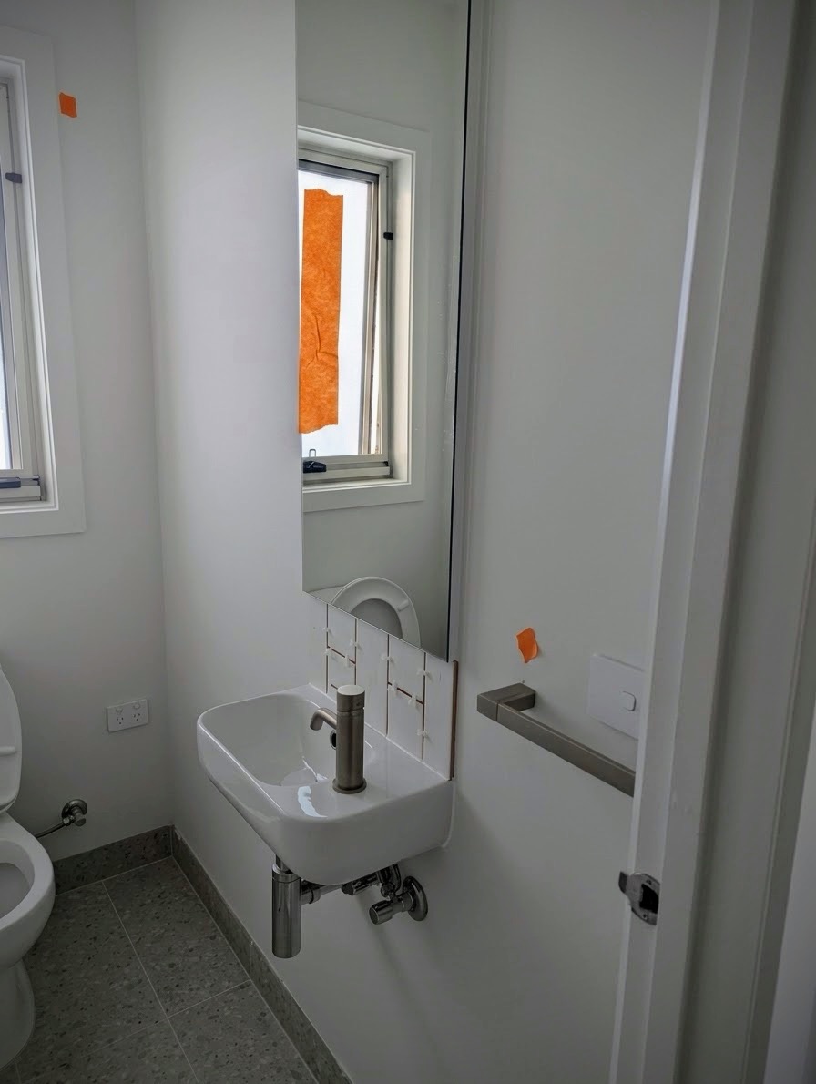 New powder room inspected by Nitpik with defect markers near vanity and door